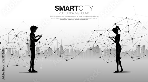 Silhouette of man and woman use mobile phone with 5G futuristic polygon dot connect line with city background . Concept for remote work from home and technology.