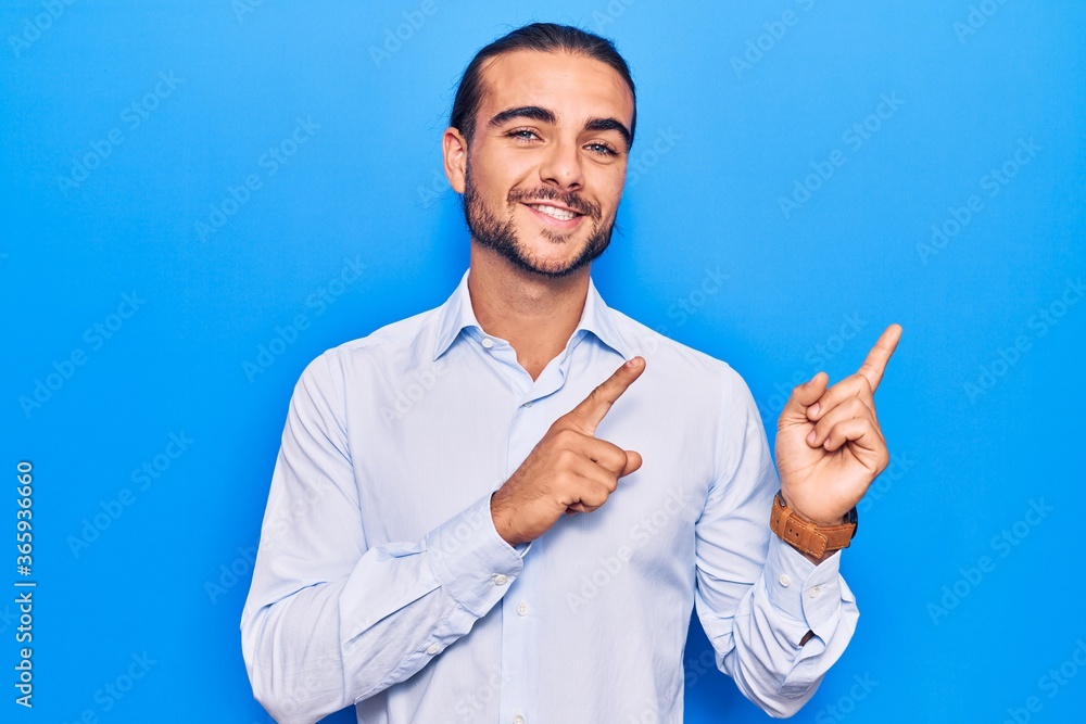 Young handsome man wearing business clothes smiling and looking at the camera pointing with two hands and fingers to the side. Young handsome man wearing business clothes smiling and looking at the camera pointing with two hands and fingers to the side.
