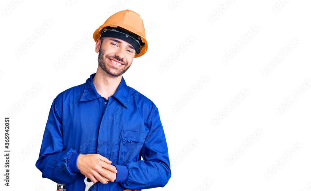 Young hispanic man wearing worker uniform with hands together and crossed fingers smiling relaxed and cheerful. success and optimistic Young hispanic man wearing worker uniform with hands together and crossed fingers smiling relaxed and cheerful. success and optimistic