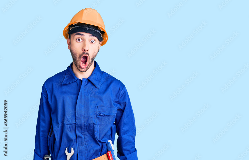 Young hispanic man wearing worker uniform afraid and shocked with surprise and amazed expression, fear and excited face. Young hispanic man wearing worker uniform afraid and shocked with surprise and amazed expression, fear and excited face.