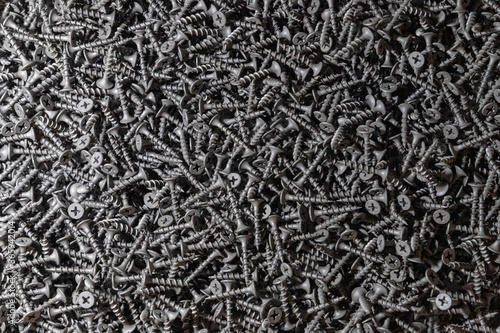 Wood screws. Texture. Background for wallpaper. A lot of black screws. View from above.