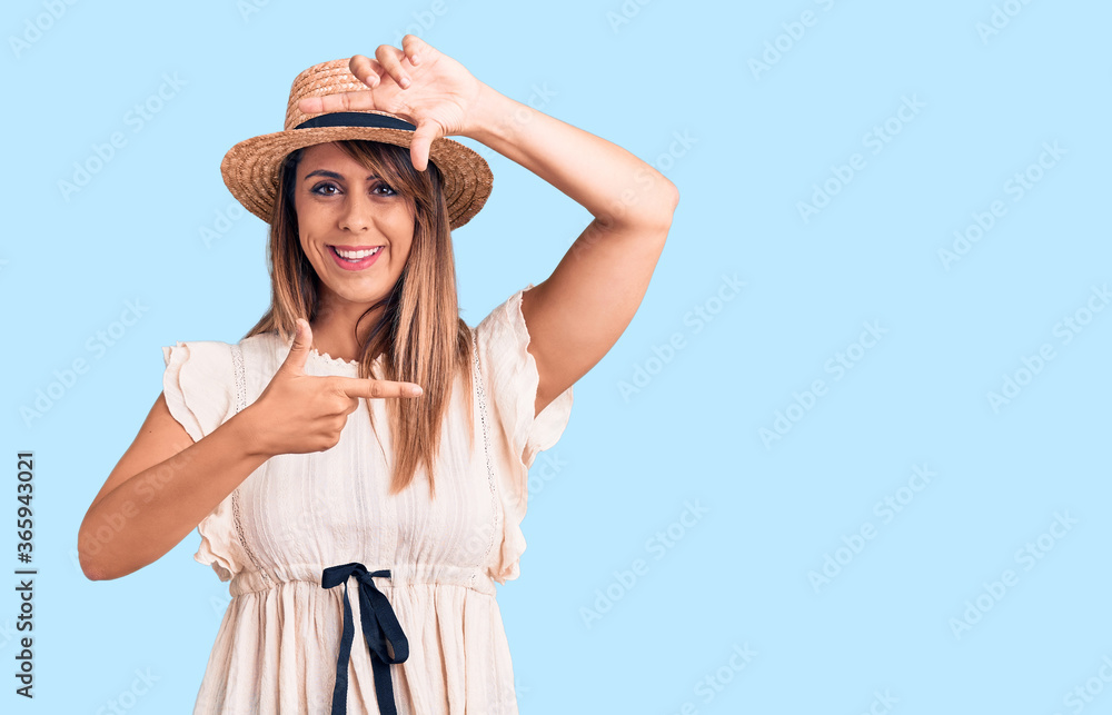 Young beautiful woman wearing summer hat and t-shirt smiling making frame with hands and fingers with happy face. creativity and photography concept. Young beautiful woman wearing summer hat and t-shirt smiling making frame with hands and fingers with happy face. creativity and photography concept.