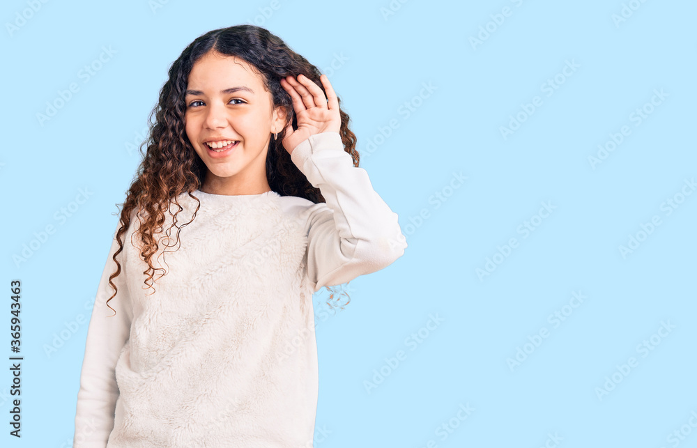 Beautiful kid girl with curly hair wearing casual clothes smiling with hand over ear listening an hearing to rumor or gossip. deafness concept. Beautiful kid girl with curly hair wearing casual clothes smiling with hand over ear listening an hearing to rumor or gossip. deafness concept.