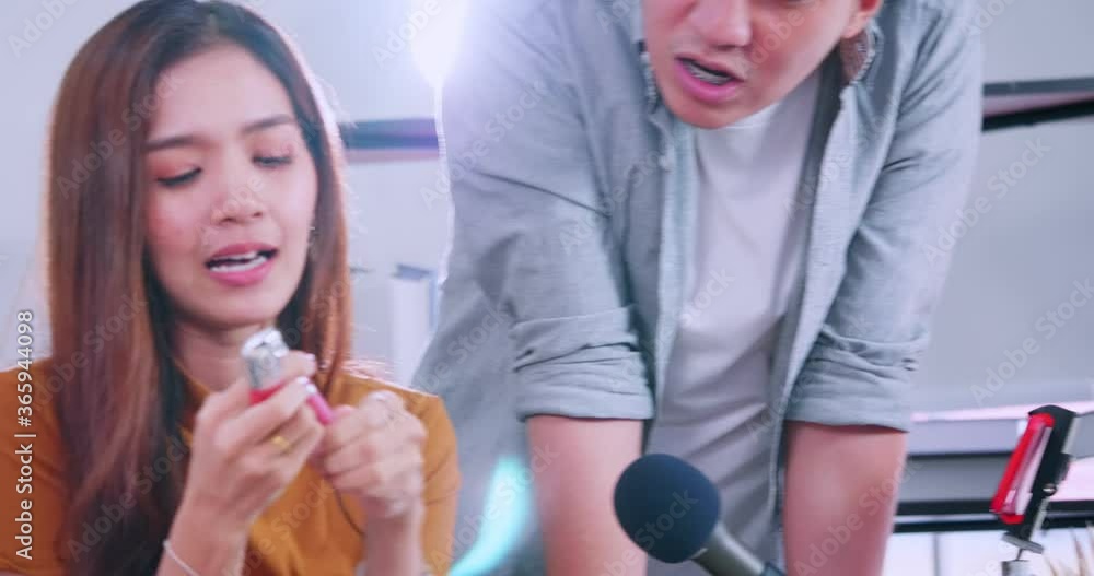 Young Asian couple bloggers are reviewing cosmetic product online by live streaming. Young Asian couple bloggers are reviewing cosmetic product online by live streaming.