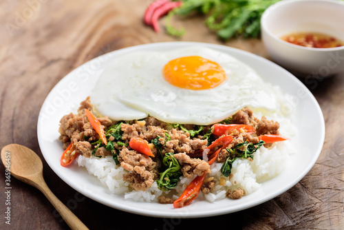 Thai food, stir-fried holy basil with minced pork and fried egg on top eating with cooked rice (Pad Kaprao Moo Kai Dao)