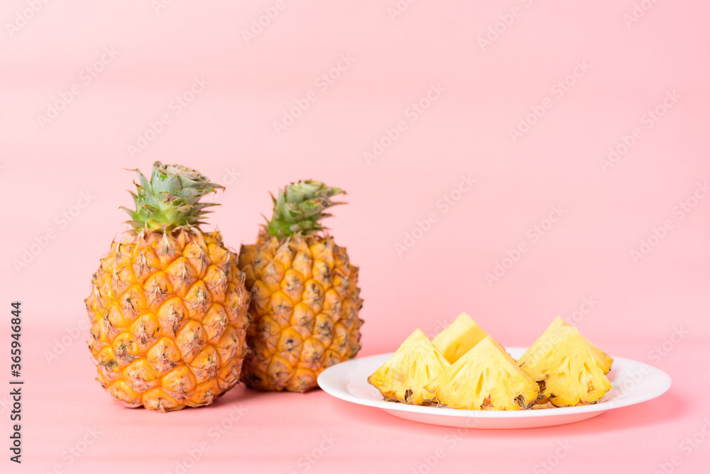 Sliced pineapple fruit on white plate with pastel pink background, Tropical fruit Sliced pineapple fruit on white plate with pastel pink background, Tropical fruit