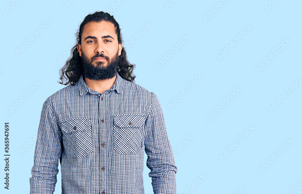 Young arab man wearing casual clothes relaxed with serious expression on face. simple and natural looking at the camera. Young arab man wearing casual clothes relaxed with serious expression on face. simple and natural looking at the camera.