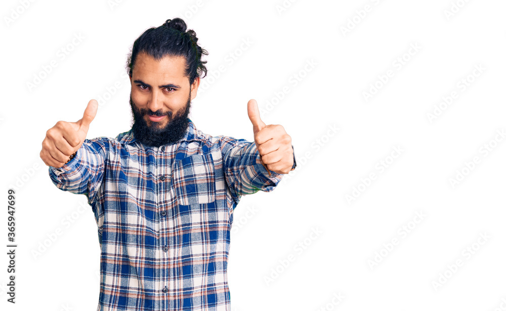 Young arab man wearing casual clothes approving doing positive gesture with hand, thumbs up smiling and happy for success. winner gesture. Young arab man wearing casual clothes approving doing positive gesture with hand, thumbs up smiling and happy for success. winner gesture.