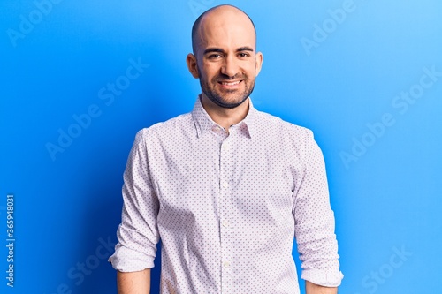 Young handsome bald man wearing elegant shirt with a happy and cool smile on face. lucky person. © Krakenimages.com