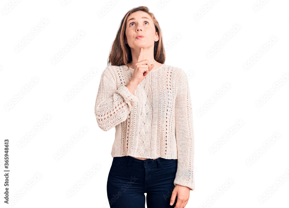 Young beautiful blonde woman wearing casual sweater thinking concentrated about doubt with finger on chin and looking up wondering Young beautiful blonde woman wearing casual sweater thinking concentrated about doubt with finger on chin and looking up wondering