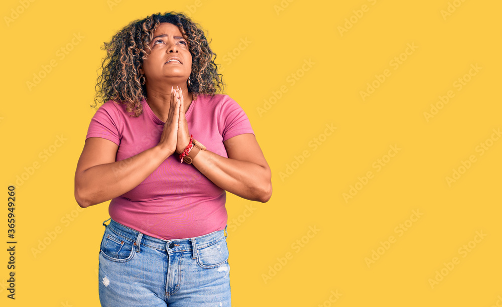 Young african american plus size woman wearing casual clothes begging and praying with hands together with hope expression on face very emotional and worried. begging. Young african american plus size woman wearing casual clothes begging and praying with hands together with hope expression on face very emotional and worried. begging.