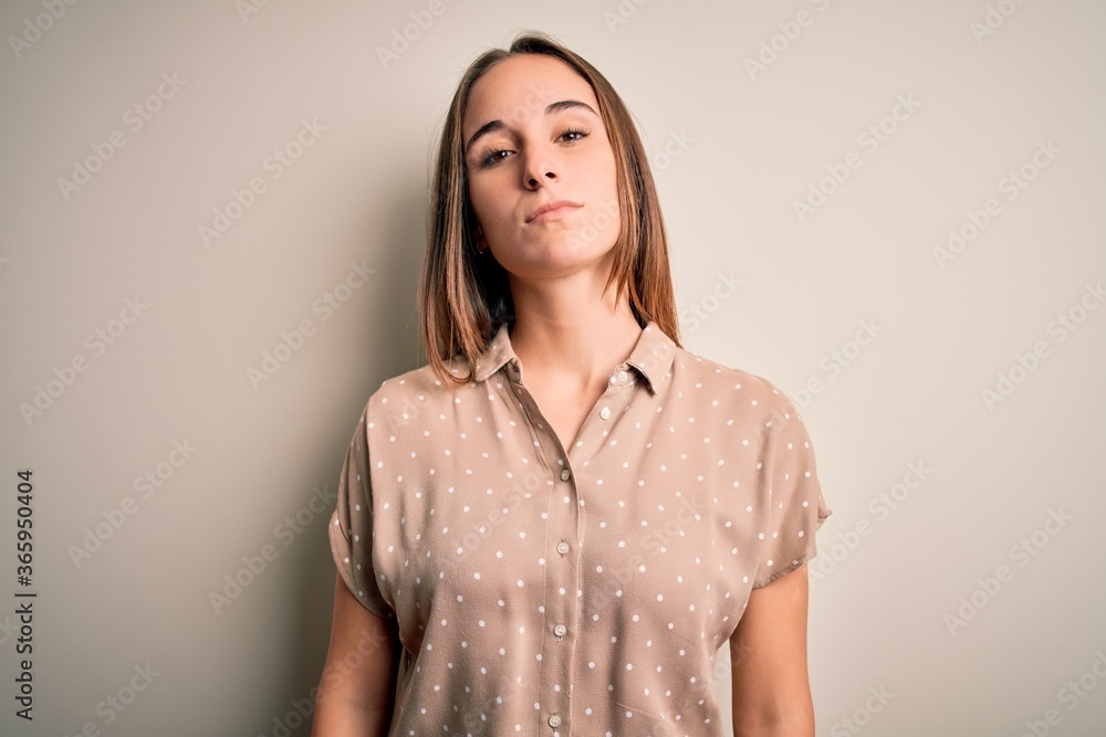 Obraz premium Young beautiful woman wearing casual shirt standing over isolated white background Relaxed with serious expression on face. Simple and natural looking at the camera.