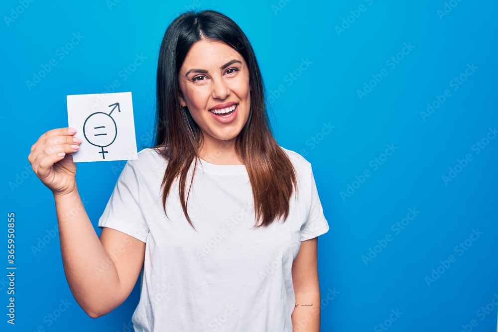 Young beautiful woman asking for sex discrimination holding paper with gender equality concept looking positive and happy standing and smiling with a confident smile showing teeth Young beautiful woman asking for sex discrimination holding paper with gender equality concept looking positive and happy standing and smiling with a confident smile showing teeth
