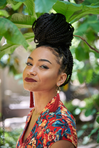 Canvastavla Stunning young biracial woman stands outside wearing floral print dress with hai