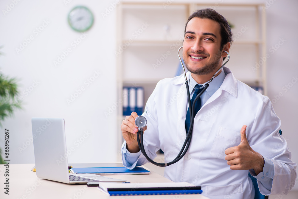 Young male handsome doctor working in the clinic