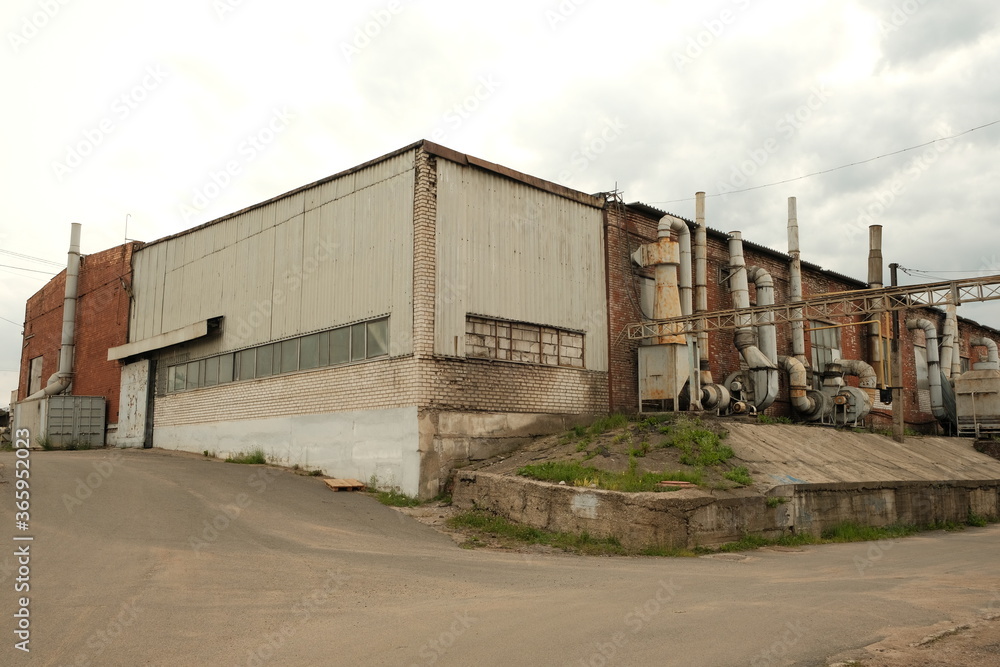 Old factory exterior with buildings and chimney. Old industrial building