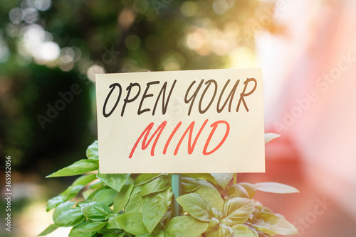 Handwriting text writing Open Your Mind. Conceptual photo to be able to understand different ideas or ways of thinking Plain empty paper attached to a stick and placed in the green leafy plants