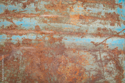 Old rusty metal plate with blue peeling paint background