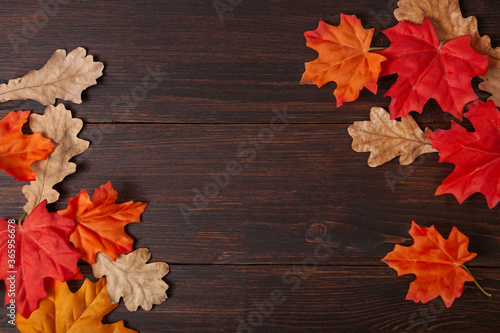 Obraz na płótnie Autumn maple leaves on brown wooden table w salonie