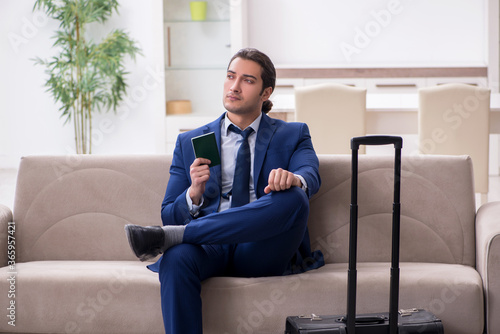 Young businessman holding passport preparing for trip