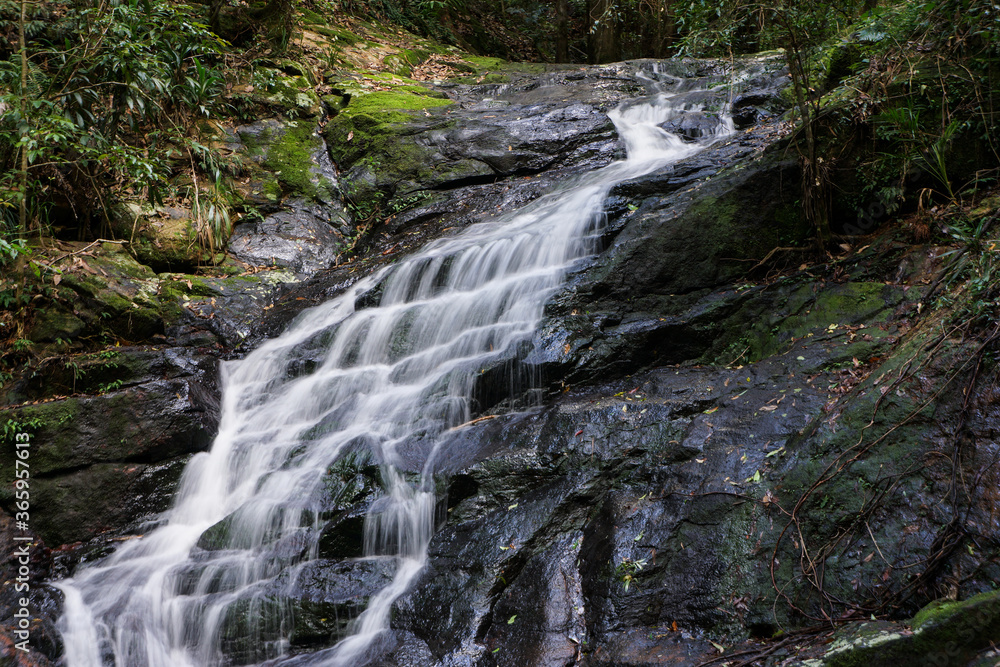 Obraz premium A small waterfall spilling down rocks.