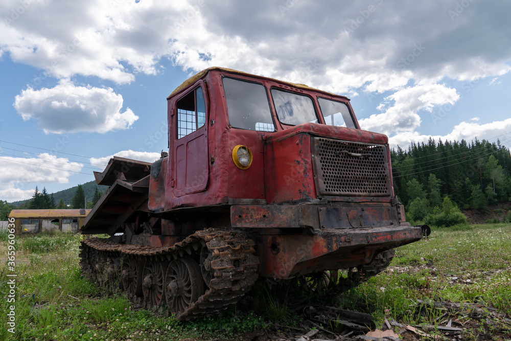 an old logging truck, rusty and abandoned in a field against the backdrop of a beautiful forest, as a symbol of the collapse of industry in Russia and Siberia. mismanagement
