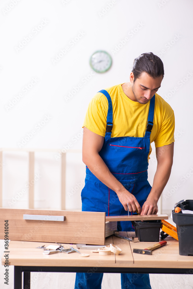 Young male carpenter working indoors Young male carpenter working indoors