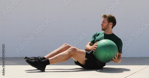 Medicine ball exercise - man doing russian twist in abs workout. photo