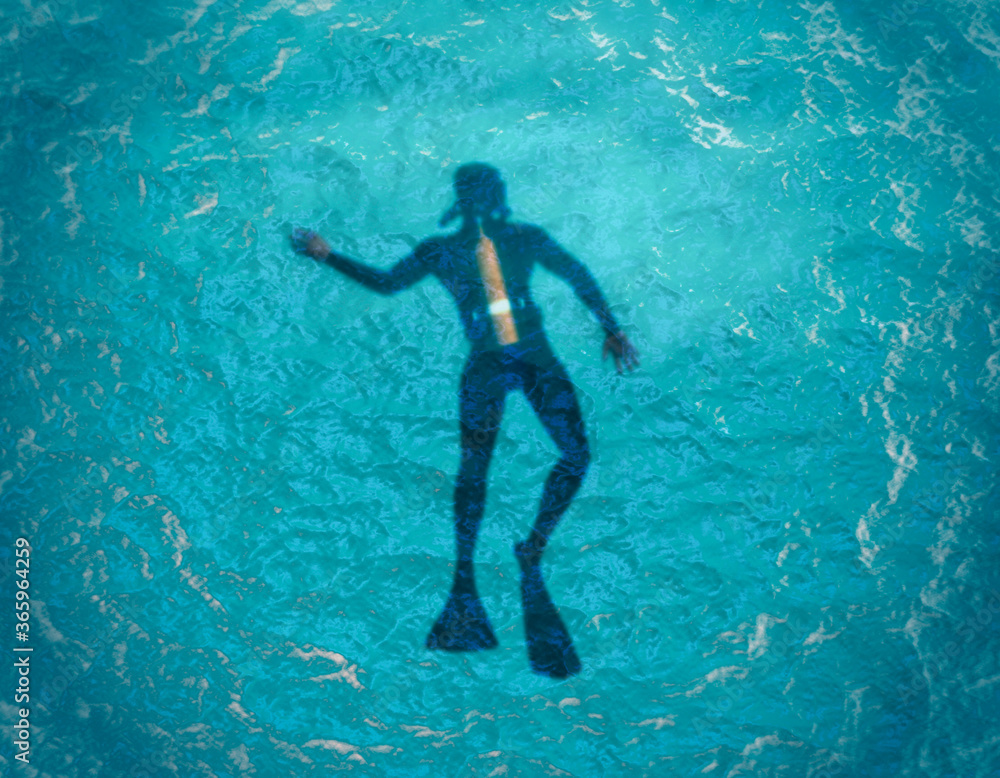 Scuba diver silhouette swimming under water in the ocean near the surface. Top vew