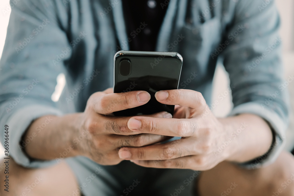 Close up man using smart phone at home Close up man using smart phone at home