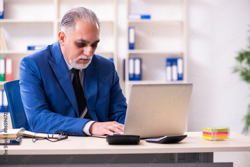 Old face injured employee sitting in the office Old face injured employee sitting in the office
