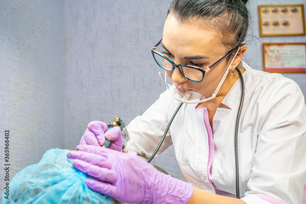 Beautiful woman making permanent makeup in cosmetology salon. Beautiful woman making permanent makeup in cosmetology salon.