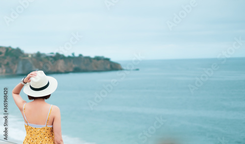 Fotografija woman wearing hat and travel on the beach.