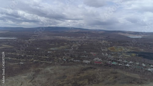 Aerial view of Orthodox cross on Mount Karabash and city. The camera flies from the city through the cross. Russia, Chelyabinsk region