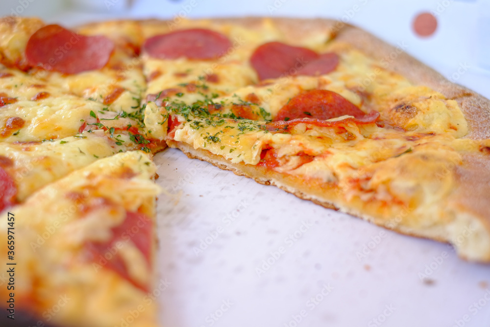 Take away Pepperoni pizza in a box delivered and started eating. High quality photo Take away Pepperoni pizza in a box delivered and started eating. High quality photo