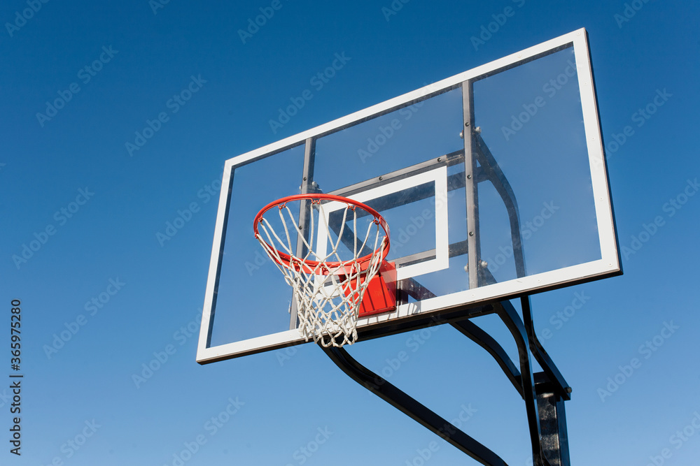 basketball board with hoop against blue sky