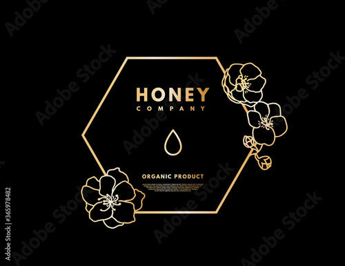 Honey logo with gold gradient honey drop in frame hexagon with flower. Label banner for company isolated from black background. Vector illustration. 