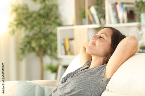 Happy adult woman relaxing in the sofa at home photo