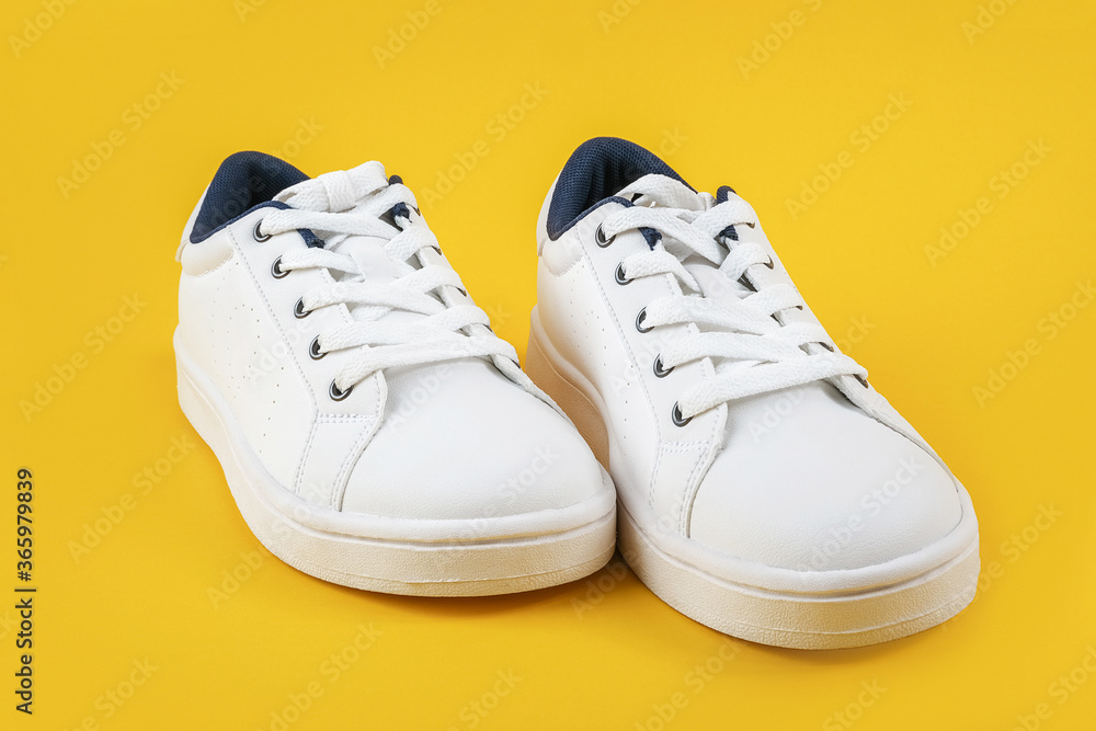 White sports shoes, sneakers with shoelaces on a yellow background. Sport lifestyle concept Top view Flat lay White sports shoes, sneakers with shoelaces on a yellow background. Sport lifestyle concept Top view Flat lay
