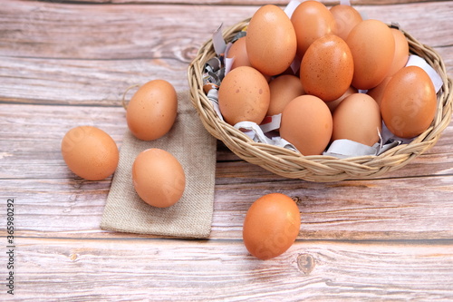 Eggs in basket on wood table background and space for text 