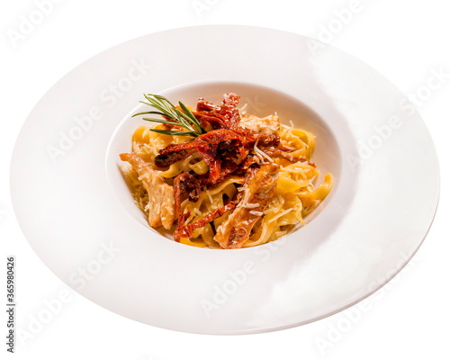 Tagliatelle pasta with chicken and sun-dried tomatoes. Isolated image on white background.