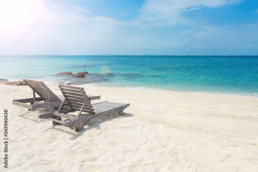 Fototapeta premium Two wooden sunbeds on paradise tropical beach. Relaxing, quite, romantic atmosphere on beautiful seashore. Holidays in summer time. Koh Munnork private island, Rayong province, Thailand.