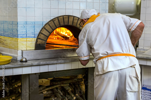 Rome, Italy 03.03.2020 The cook checks the readiness of dish in oven