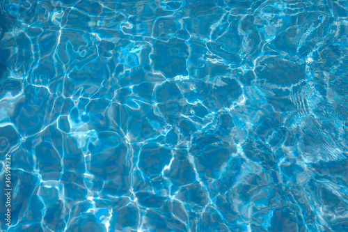 Surface of Blue ripped water in the swimming pool. Background of water in the swimming pool.
