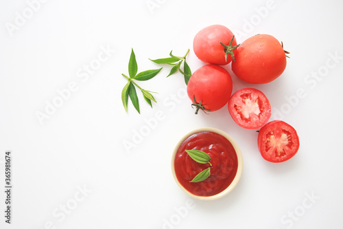 Bowl of ketchup or tomatoes sauce with ingredients on white background.