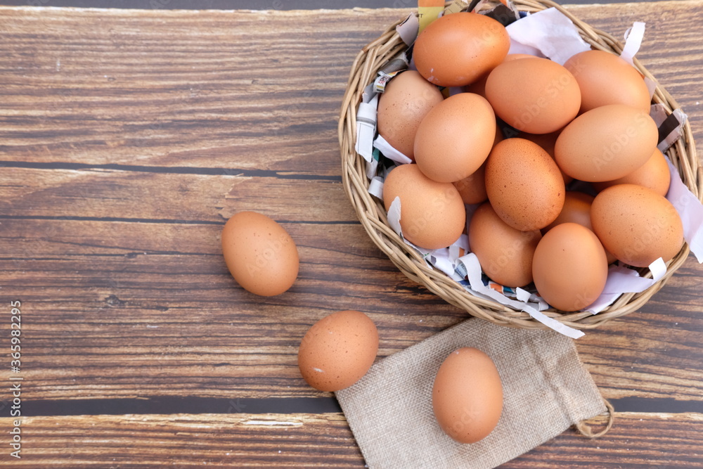 Chicken eggs in basket on wood table background and space for text Chicken eggs in basket on wood table background and space for text