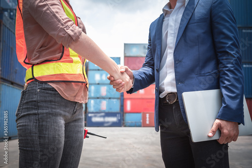 Businessman and Container Shipping Worker Handshake Together for Cooperation Shipment in Logistic Warehouse, Business Partnership Greeting Handshaking After Discussion Containers Transport Dealing. © Maha Heang 245789