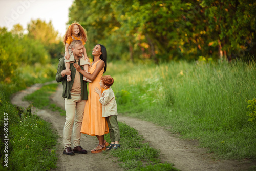 Happy international family on a summer walk in the park.