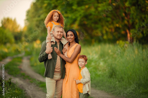 Happy international family on a summer walk in the park.