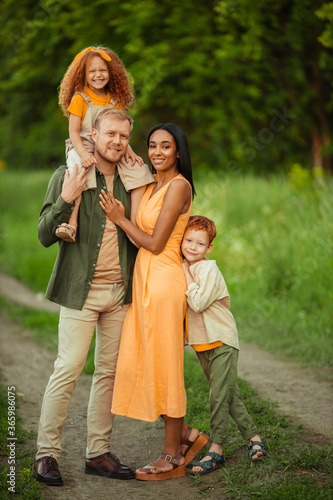 Happy international family on a summer walk in the park.